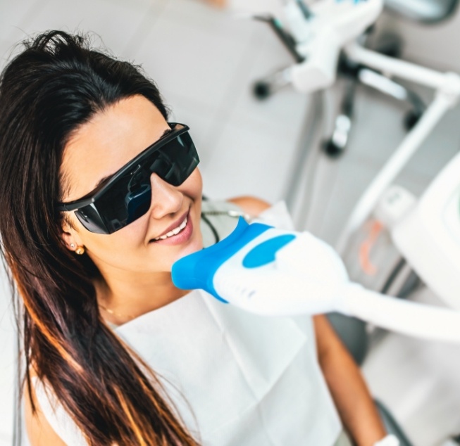 Woman in dental chair getting professional teeth whitening