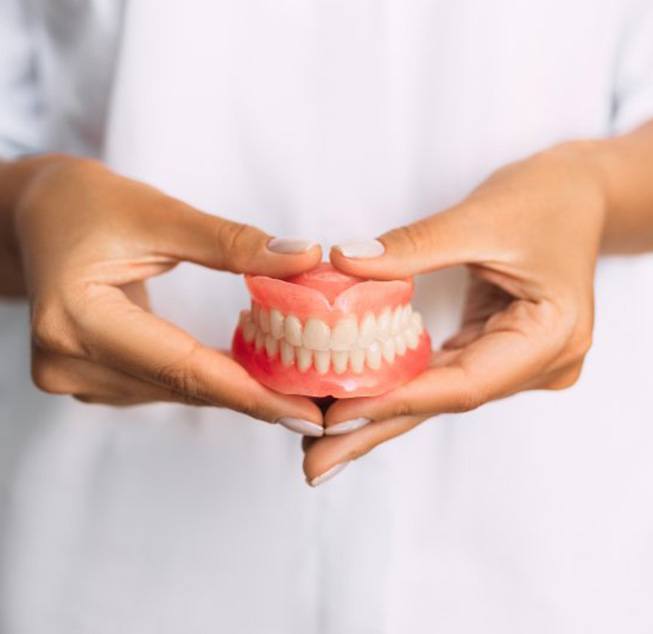 Lady presents viewer with dentures