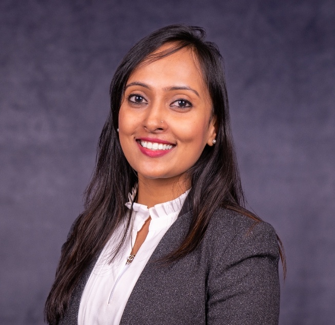Doctor Parveen smiling in gray business jacket