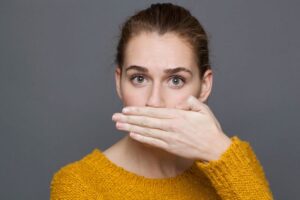 Embarrassed woman covering her mouth