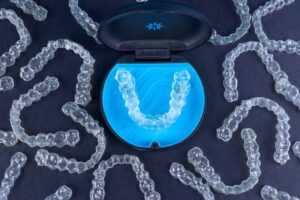 Invisalign tray surrounded by clear aligners. 