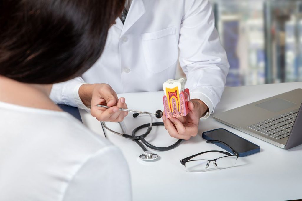 A dentist explaining a root canal treatment to a patient.